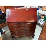 A mahogany bureau with serpentine front and ball and claw legs COLLECT ONLY