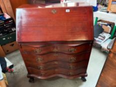 A mahogany bureau with serpentine front and ball and claw legs COLLECT ONLY