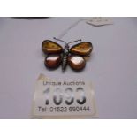 A vintage butterfly brooch in amber and silver.