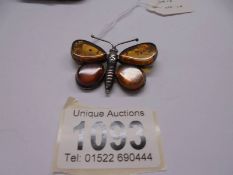 A vintage butterfly brooch in amber and silver.