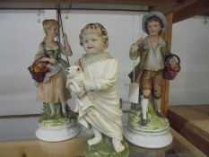A pair of fruit seller figures and a figure of a toddler.
