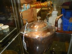 A Victorian copper kettle with heat resistant handle.