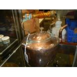 A Victorian copper kettle with heat resistant handle.