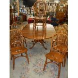 A good oak extending dining table with a set of 8 chairs with crinoline stretchers. COLLECT ONLY.