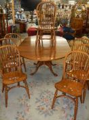 A good oak extending dining table with a set of 8 chairs with crinoline stretchers. COLLECT ONLY.