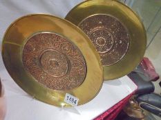 A pair of brass and copper wall plaques.