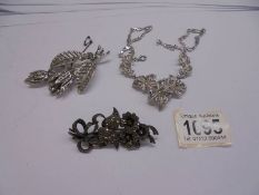 A silver marcasite flower spray brooch together with an un-marked marcasite brooch and necklace.