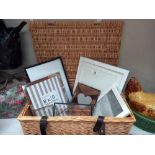 A wicker hamper and quantity of modern photo frames