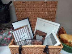 A wicker hamper and quantity of modern photo frames