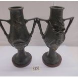 A pair of Art Nouveau white metal vases with a patinated bronzed finish on marble bases, 27 cm tall.