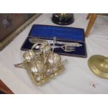 A silver plate egg cup stand with spoons (M & Co.,) and a cased pair of silver plate fish servers.