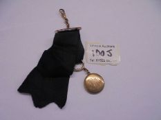 A 19th century 20ct gold opening locket with a black silk ribbon, stamped 10ct gold, 5.7 grams.