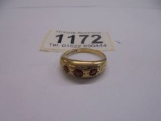 A 9ct gold ring set three garnets, size P, 3.15 grams.
