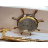 A ship's wheel style barometer.