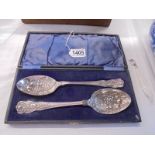 A cased pair of silver plate fruit decorated spoons.