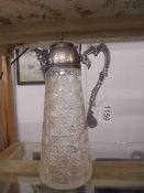 A hobnail cut glass claret jug with plated top and mask on spout.