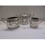 An engraved silver plate tea pot together with a sugar bowl and milk jug.