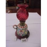 A porcelain chamber oil lamp with red glass chimney.