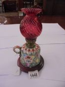 A porcelain chamber oil lamp with red glass chimney.