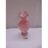 An antique pink glass jug with applied flower, 17cm.