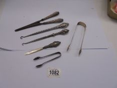 A mixed lot inc. silver handles button hooks, silver handled glove stretchers, silver sugar tongs