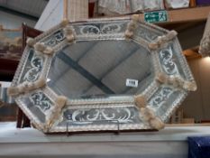 A 1920s venetian wall mirror, the elongated octagonal cushion shaped frame with gilt flower dividers