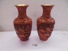 A pair of Chinese cinabar vases with floral panels, 23 cm tall.