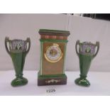 A ceramic three piece clock garniture with quartz movement, clock 20 cm, side pieces 17 cm.