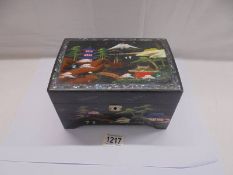 A Japanese hand painted lacquered musical jewellery box.