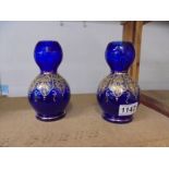 A pair of hand decorated blue glass vases. 16.5cm.