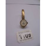 A ladies 9ct gold Excaliber 17 jewel wrist watch on a yellow metal bracelet.