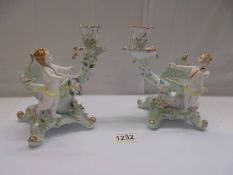 A pair of continental porcelain cherub candleholders.