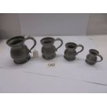 A set of four antique pewter measure, half pint, one gill, half gill and quarter gill.