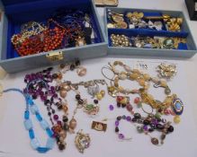 A jewellery box containing necklaces, brooches, watches etc.,