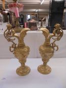A pair of heavy gilt metal ewers (one a/f, crack to spout).