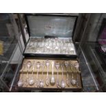 A cased set of 12 cake forks and a cased set of 12 teaspoons.