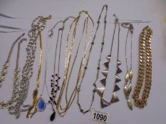 Ten white and yellow metal necklaces.