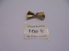 A brooch designed as a bow in 9ct gold, 3.4 grams.