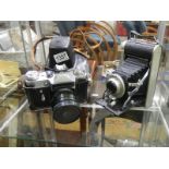 A Coronet Rapide folding camera and a Zenit camera.