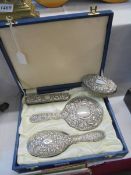A cased silver backed dressing table set with one extra brush.