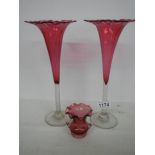 A pair of cranberry glass frilled top vases and a small cranberry glass two handled posy vase.