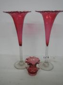 A pair of cranberry glass frilled top vases and a small cranberry glass two handled posy vase.