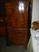 A mahogany veneered two door cupboard over four drawer base and with pull out slide, COLLECT ONLY.