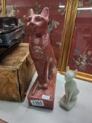 Two Egyptian cat figurines - one larger in red stone the smaller in a white stone