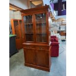 A darkwood stained bookcase/display cabinet with cupboard. COLLECT ONLY.