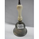 An hold hand bell with ceramic handle.