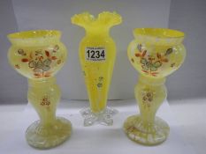 A pair of early 20th century hand painted yellow glass vases and one other.
