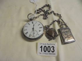 A silver pocket watch (not working) on a silver chain with silver fob and silver vesta (chain/fob/