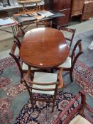 A darkwood stained extending dining table with five chairs. COLLECT ONLY.