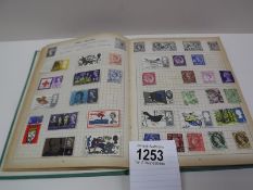 A green stamp album with several incomplete pages of stamps from around the world.
